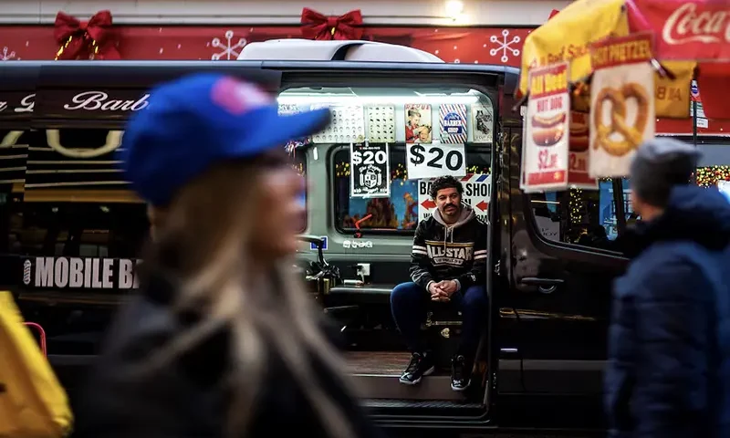 An independent barber waits for customers on his van in a local street in New York, U.S., December 25, 2023. REUTERS/Eduardo Munoz/File Photo