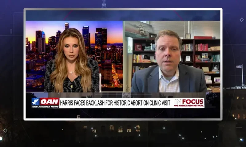 Video still from In Focus on One America News Network showing a split screen of the host on the left side, and on the right side is the guest, Herbie Newell.