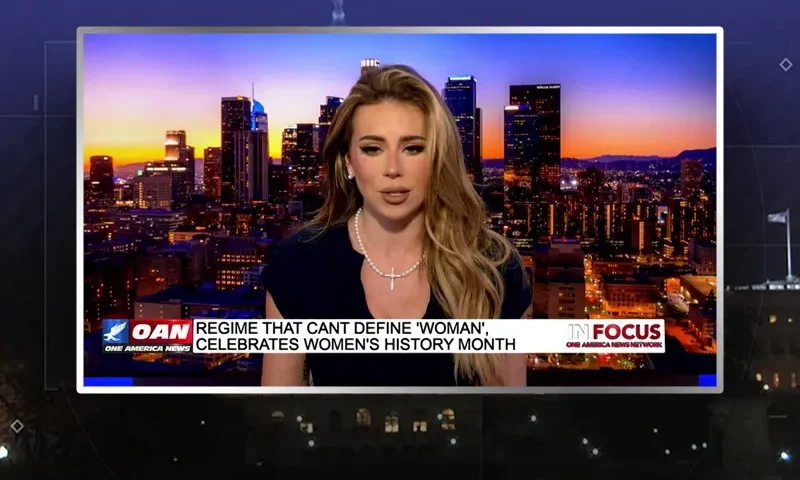 Video still of the host of In Focus at the desk of their talk show on One America News Network.