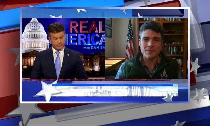 Video still from Real America on One America News Network showing a split screen of the host on the left side, and on the right side is the guest, Joe Kent.