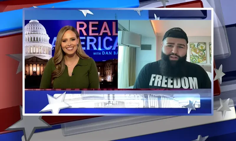 Video still from Real America on One America News Network showing a split screen of the host on the left side, and on the right side is the guest, Jimmy Levy.