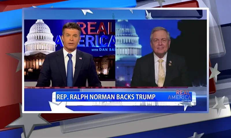 Video still from Real America on One America News Network showing a split screen of the host on the left side, and on the right side is the guest, Rep. Ralph Norman.