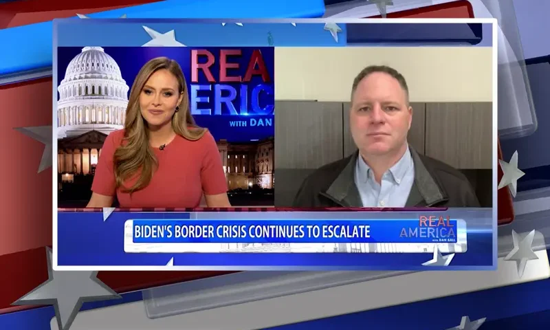 Video still from Real America on One America News Network showing a split screen of the host on the left side, and on the right side is the guest, Tom Norton.