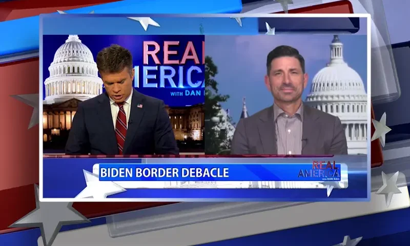 Video still from Real America on One America News Network showing a split screen of the host on the left side, and on the right side is the guest, Chad Wolf.