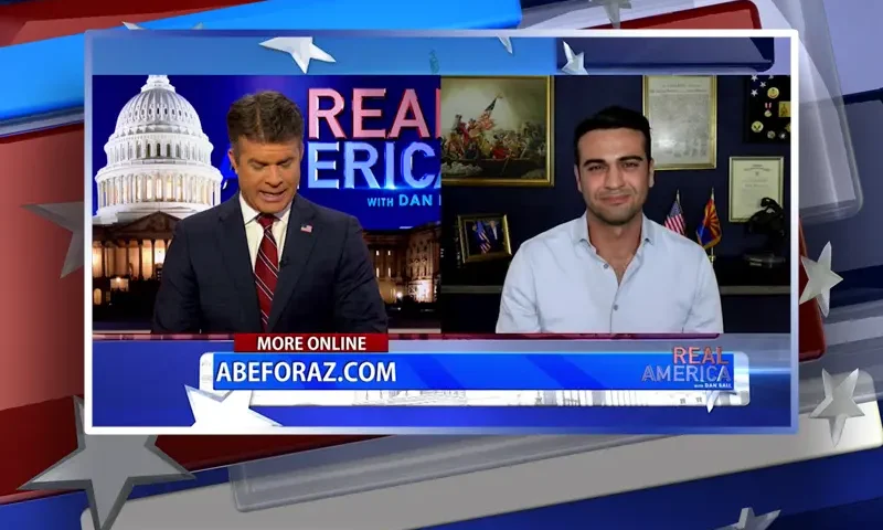 Video still from Real America on One America News Network showing a split screen of the host on the left side, and on the right side is the guest, Abe Hamadeh.