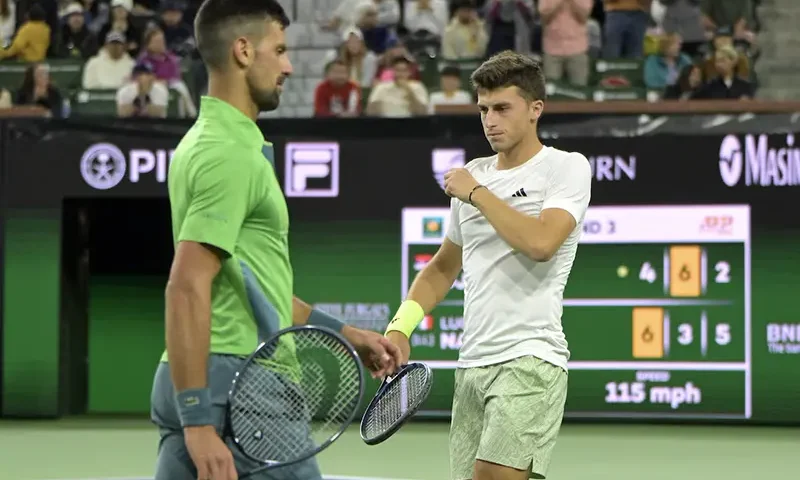 Novak Djokovic (SRB) and Luca Nardi (ITA) pass as they change sides during their third round match in the BNP Paribas Open at the Indian Wells Tennis Garden. Mandatory Credit: Jayne Kamin-Oncea-USA TODAY Sports