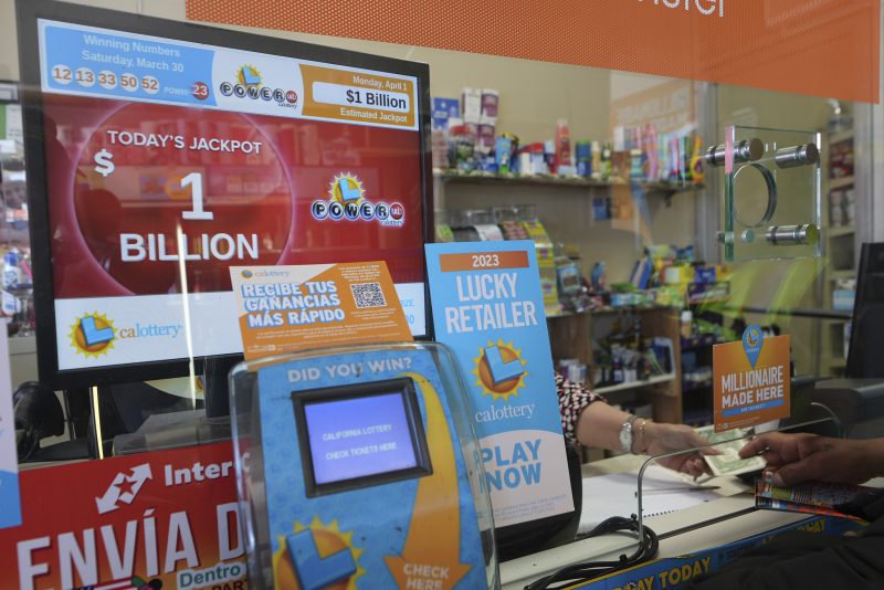 Lottery players buy Powerball tickets at the Las Palmitas Mini Market in in the Fashion District downtown Los Angeles on Monday, April 1, 2024. A $1 billion Powerball jackpot will tempt lottery players who think they just might hit it rich after three months without a big winner. No one has won Powerball's jackpot since New Year's Day, a stretch of 38 consecutive drawings without anyone matching the game's six numbers. (AP Photo/Damian Dovarganes)