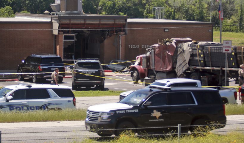Emergency personnel work at the scene after an 18-wheeler crashed into the Texas Department of Public Safety Office in Brenham, Texas, Friday, April 12, 2024. A suspect is in custody in connection to a commercial vehicle crash at the Texas Department of Public Safety office in the rural town west of Houston. Texas DPS officials say multiple injuries were reported in the crash. (AP Photo/Lekan Oyekanmi)