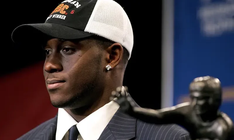 Winner of the 2005 Heisman Trophy, Reggie Bush of the University of Southern California, poses with the award in New York, December 10, 2005. REUTERS/Jeff Zelevansky/File Photo
