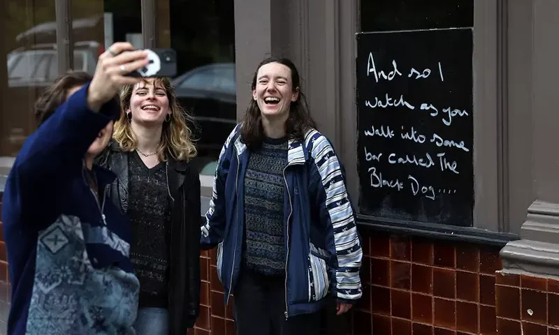 Fans of Taylor Swift take images next to lyrics from the song The Black Dog by Taylor Swift, written outside The Black Dog pub, believed by its owners to have been referenced in the track, in London, Britain, April 22, 2024. REUTERS/Toby Melville