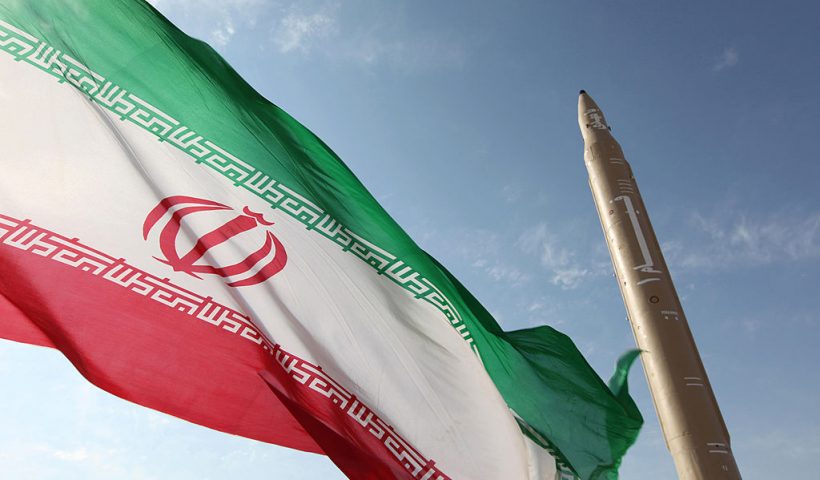 A picture taken on August 20, 2010 shows an Iranian flag fluttering at an undisclosed location in the Islamic republic next to a surface-to-surface Qiam-1 (Rising) missile which was test fired a day before Iran was due to launch its Russian-built first nuclear power plant. Iranian Defence Minister Ahmad Vahidi said the missile was entirely designed and built domestically and powered by liquid fuel. AFP PHOTO/VAHID REZA ALAEI (Photo credit should read VAHID REZA ALAEI/AFP via Getty Images)