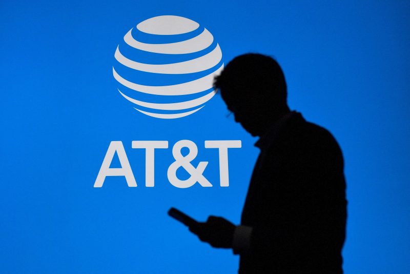 A visitor walks past US multinational telecommunications AT&T logo at the Mobile World Congress (MWC), the telecom industry's biggest annual gathering, in Barcelona on February 27, 2023. (Photo by Pau BARRENA / AFP) (Photo by PAU BARRENA/AFP via Getty Images)