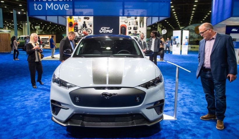 Attendees admire the 2024 Ford Mustang Mach-E Rally during the North American International Auto Show at the Huntington Place convention center in Detroit, Michigan, on September 14, 2023. (Photo by Matthew Hatcher / AFP) (Photo by MATTHEW HATCHER/AFP via Getty Images)