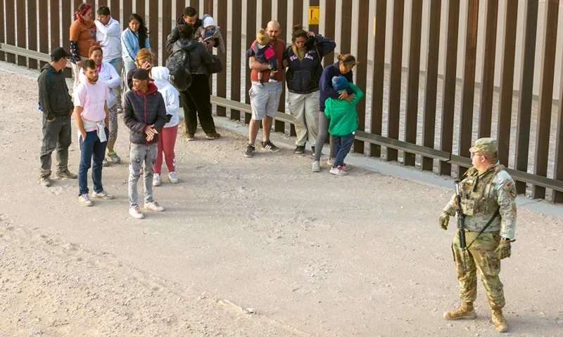 EL PASO, TEXAS - MARCH 13: In an aerial view, a Texas National Guard soldier watches over immigrants after they crossed the U.S.-Mexico border to request asylum on March 13, 2024 in El Paso, Texas. The border between the two nations stretches nearly 2,000 miles, from the Gulf of Mexico to the Pacific Ocean and is marked by fences, deserts, mountains and the Rio Grande, which runs the entire length of Texas. The politics and controversies surrounding border and immigration issues have become dominant themes in the U.S. presidential election campaign. (Photo by John Moore/Getty Images)