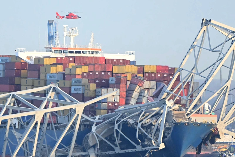 TOPSHOT-US-TRANSPORT-INCIDENT
TOPSHOT - The steel frame of the Francis Scott Key Bridge sit on top of a container ship after the bridge collapsed in Baltimore, Maryland, on March 26, 2024. The bridge collapsed after being struck by a container ship, sending multiple vehicles and up to 20 people plunging into the harbor below. "Unfortunately, we understand that there were up to 20 individuals who may be in the Patapsco River right now as well as multiple vehicles," Kevin Cartwright of the Baltimore Fire Department told CNN. Ship monitoring website MarineTraffic showed a Singapore-flagged container ship called the Dali stopped under the bridge. (Photo by Mandel NGAN / AFP) (Photo by MANDEL NGAN/AFP via Getty Images)