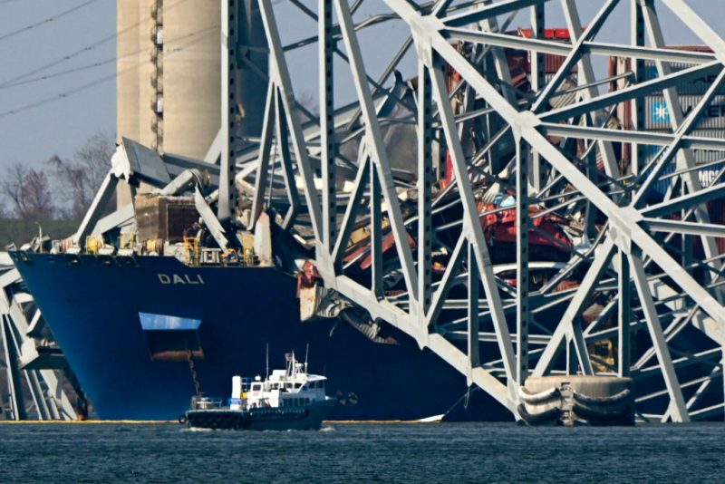 The collapsed Francis Scott Key Bridge lies on top of the container ship Dali in Baltimore, Maryland, on March 29, 2024, as clean-up work begins.. Cranes began arriving March 28 at the scene of the catastrophic bridge collapse over Baltimore harbor, as authorities shifted to a clean-up phase of the recovery and warned of extensive work before the major US port can reopen. Four men, all Latin American immigrants, are believed to have been killed when the Singapore-flagged container ship lost power and careened into a bridge support column. (Photo by Mandel NGAN / AFP) (Photo by MANDEL NGAN/AFP via Getty Images)