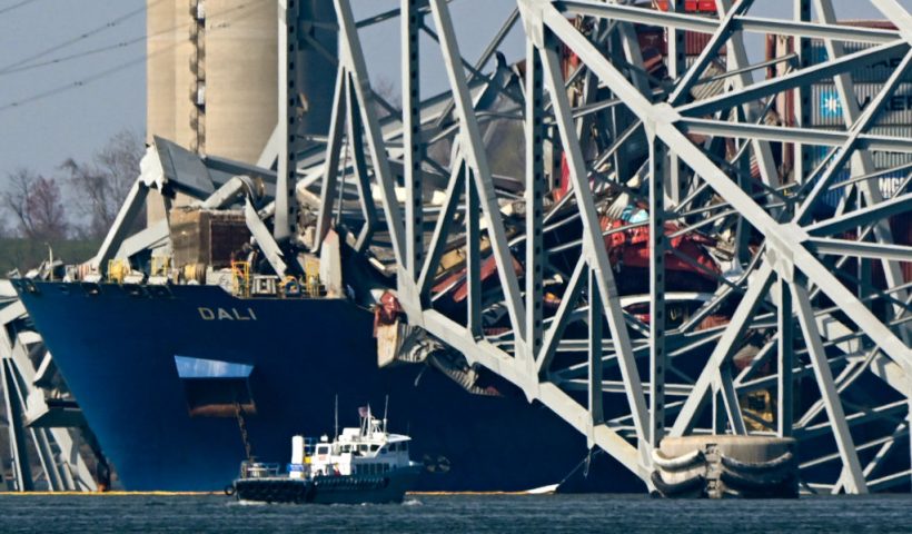 The collapsed Francis Scott Key Bridge lies on top of the container ship Dali in Baltimore, Maryland, on March 29, 2024, as clean-up work begins.. Cranes began arriving March 28 at the scene of the catastrophic bridge collapse over Baltimore harbor, as authorities shifted to a clean-up phase of the recovery and warned of extensive work before the major US port can reopen. Four men, all Latin American immigrants, are believed to have been killed when the Singapore-flagged container ship lost power and careened into a bridge support column. (Photo by Mandel NGAN / AFP) (Photo by MANDEL NGAN/AFP via Getty Images)