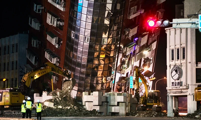 TAIWAN-EARTHQUAKE Emergency personnel stand in front of a partially collapsed building leaning over a street in Hualien on April 3, 2024, after a major earthquake hit Taiwan's east. At least nine people were killed and more than 1,000 injured on April 3 by a powerful earthquake in Taiwan that damaged dozens of buildings and prompted tsunami warnings that extended to Japan and the Philippines before being lifted. (Photo by Sam Yeh / AFP) (Photo by SAM YEH/AFP via Getty Images)