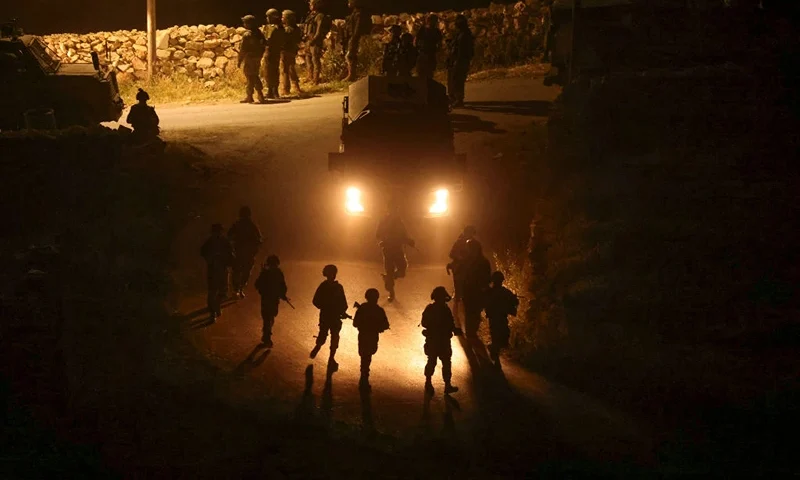 TOPSHOT - Israeli forces walk during the demolition of the house of a Palestinian man accused of participating in a deadly attack in the Israeli city of Raanana on January 15, 2024, in the village of Bani Naim, in the occupied West Bank on April 17, 2024. (Photo by HAZEM BADER / AFP) (Photo by HAZEM BADER/AFP via Getty Images)