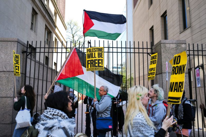 Pro-Palestinian supporters wave flags in front of the entrance of Columbia University which is occupied by pro-Palestine protesters in New York on April 22, 2024. US President Joe Biden condemned any anti-Semitism on college campuses April April 21, 2024 as pro-Palestinian protesters at Columbia University spent their fifth day demanding the school sever financial ties with key US ally Israel. (Photo by Charly TRIBALLEAU / AFP) (Photo by CHARLY TRIBALLEAU/AFP via Getty Images)