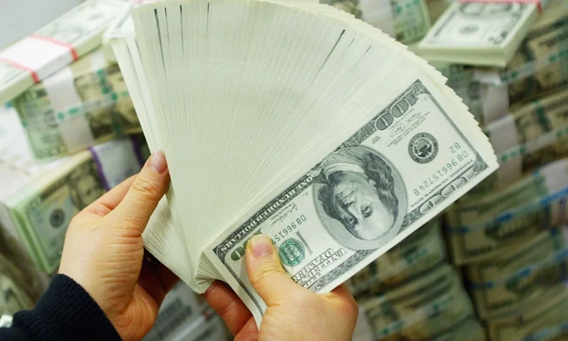 SEOUL, SOUTH KOREA - FEBRUARY 22: A South Korean banker carries US dollar bank notes at the Korea Exchange bank on February 22, 2005 in Seoul, South Korea. The South Korean won jumped to its highest intraday level in more than seven years in domestic trade on Tuesday, boosted by strong foreign equity buying and exporter deals. (Photo by Chung Sung-Jun/Getty Images)