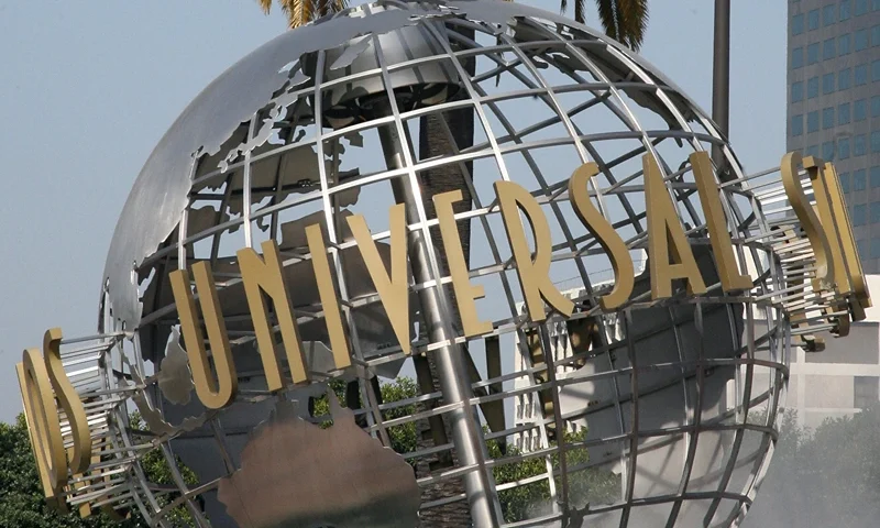 The entrance of Universal Studios in Ho... Hollywood, UNITED STATES: The entrance of Universal Studios in Hollywood is pictured 09 April 2007. Universal Studios Hollywood is the original Universal Studios theme park, created initially to offer tours of the real Universal Studios soundstages and sets. It is one of four fully-fledged Universal Studios Theme Parks, along with Universal Studios Orlando, Universal Studios Japan, and the upcoming Universal Studios Singapore, which will be completed by 2010. From the beginning, Universal has offered tours of its studio. In the silent-film days, Carl Laemmle's tour included a chance to buy fresh produce, since then-rural Universal City was still in part a working farm. Shortly after MCA took over Universal Pictures in 1962, accountants suggested a tour stop in the studio commissary would increase profits, and in 1964, the modest tour was expanded to include a series of dressing room walk-throughs, peeks at actual production, and later, staged events. This grew over the years into a full-blown theme park - the narrated tram (formerly "Glamortram") tour still runs through the studio's active backlot, but the staged events, stunt demonstrations and high-tech rides overshadow the motion-picture production that once lured fans in Universal Studios Hollywood. AFP PHOTO/GABRIEL BOUYS (Photo credit should read GABRIEL BOUYS/AFP via Getty Images)