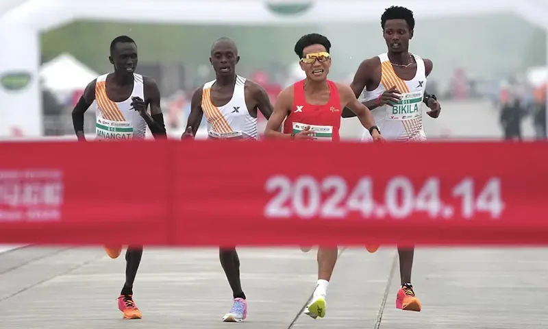 Chinese runner He Jie, Ethiopian Dejene Hailu Bikila and Kenyans Robert Keter and Willy Mnangat take part in a half-marathon in Beijing, China April 14, 2024. cnsphoto via REUTERS/File Photo