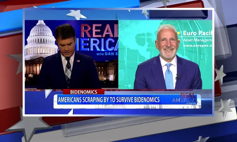 Video still from Real America on One America News Network showing a split screen of the host on the left side, and on the right side is the guest, Peter Schiff.