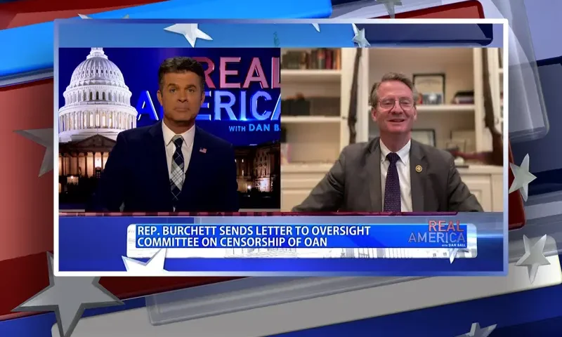 Video still from Real America on One America News Network showing a split screen of the host on the left side, and on the right side is the guest, Rep. Tim Burchett.