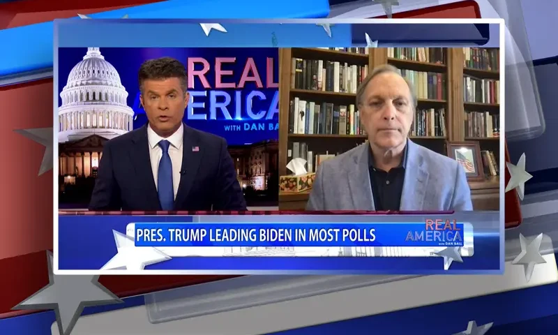 Video still from Real America on One America News Network showing a split screen of the host on the left side, and on the right side is the guest, Rep. Andy Biggs.