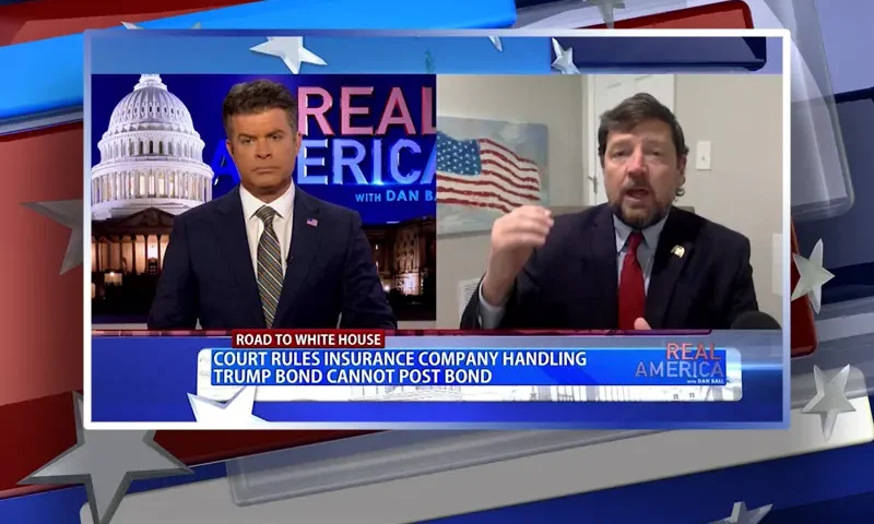 Video still from Real America on One America News Network showing a split screen of the host on the left side, and on the right side is the guest, Ed Martin.
