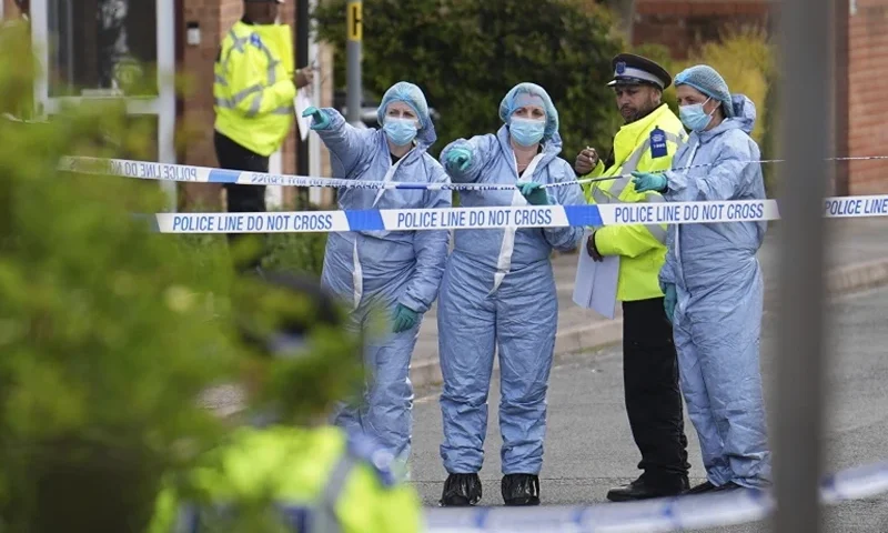 1 of 12 | Forensics officers gesture near the scene of an attack in Hainault, north east London, Tuesday April 30, 2024. A man wielding a sword attacked members of the public and police officers in a east London suburb, killing a 13-year-old boy and injuring four others, authorities said Tuesday. The man was arrested at the scene, police said. Chief Supt. Stuart Bell said the incident is not being treated as terror-related or a "targeted attack." (Jordan Pettitt/PA via AP)