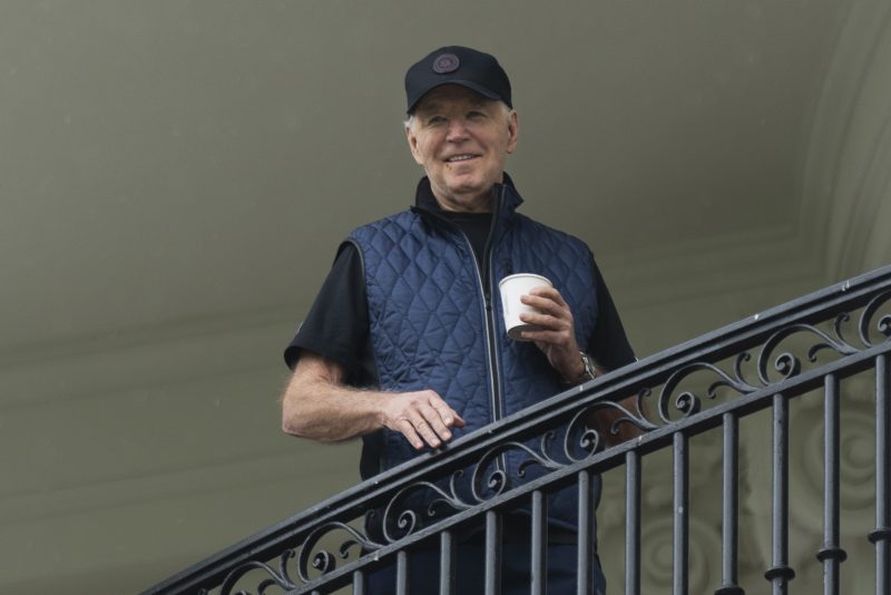 President Joe Biden watches first lady Jill Biden from the White House's Truman Balcony, as she hosts the 2nd annual Joining Forces Military Kids Workout on the South Lawn, Saturday, April 27, 2024. (AP Photo/Manuel Balce Ceneta)