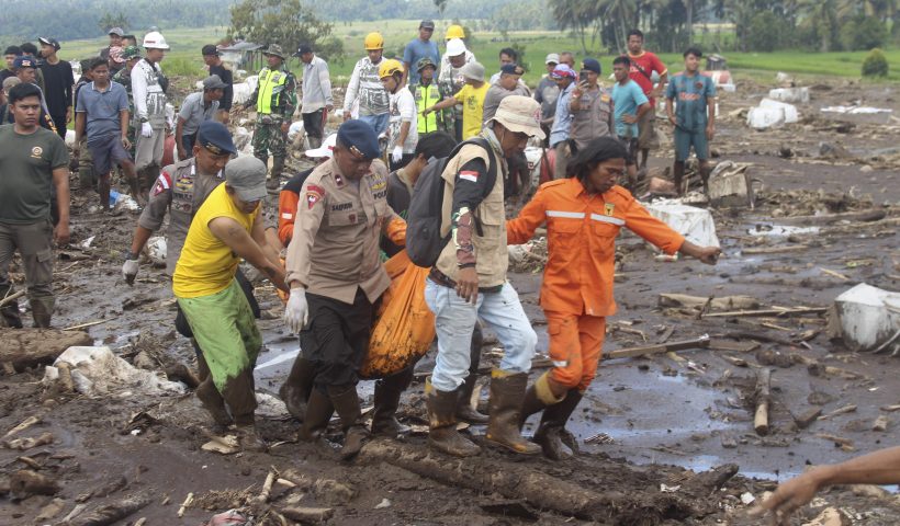 Rescuers carry the body of a victim of a flash flood in Tanah Datar, West Sumatra, Indonesia, Monday, May 13, 2024. Heavy rains and torrents of cold lava and mud flowing down a volcano's slopes on Indonesia's Sumatra island triggered flash floods causing a number of people dead and missing, officials said Sunday. (AP Photo/Ali Nayaka)