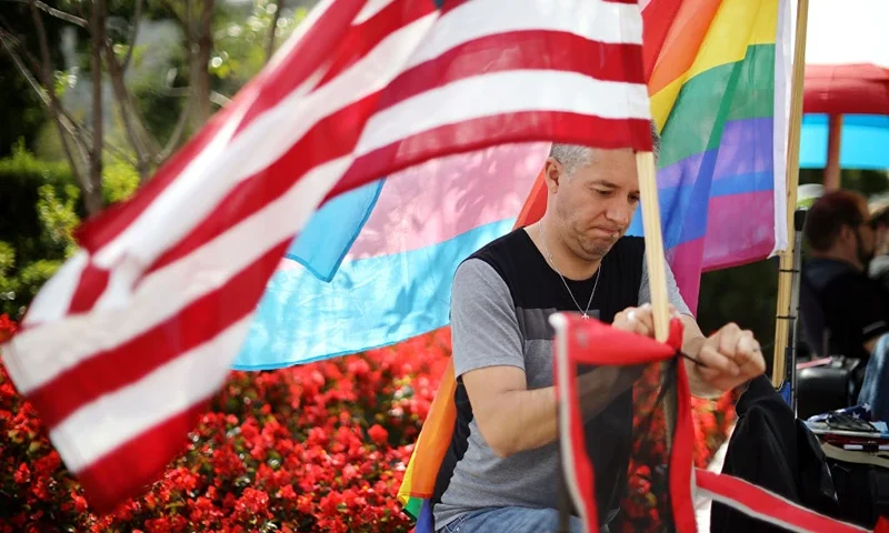 WASHINGTON, DC - OCTOBER 07: Eddie Reynoso of San Diego, California, attaches an American flag his chair while waiting in line outside the U.S. Supreme Court building for the chance to attend Tuesday's arguments during the court's new term October 07, 2019 in Washington, DC. In place outside the court since Saturday night, Reynoso is first in line to hear Tuesday's arguments in Bostock v. Clayton Co., GA, where the justices will consider whether employers may fire employees for being gay or transgender. With Chief Justice John Roberts in the lead, the court is scheduled to hear cases involving gun control, abortion, L.G.B.T. rights and immigration during this term. (Photo by Chip Somodevilla/Getty Images)