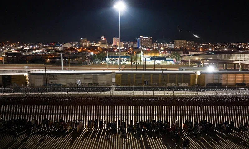 CIUDAD JUAREZ, MEXICO - DECEMBER 21: Migrants spend the night in a long line outside the U.S.-Mexico border fence while waiting to make asylum claims in El Paso, Texas on December 21, 2022 as seen from Ciudad Juarez, Mexico. Texas Governor Greg Abbott ordered 400 troops to the U.S.-Mexico border at El Paso, which is under a state of emergency due to a surge of migrants crossing from Mexico into the city. Border officials expect an even larger migrant surge at the border if the pandemic era Title 42 regulation is lifted. (Photo by John Moore/Getty Images)