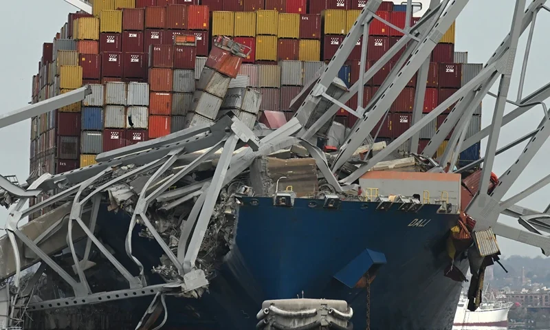 TOPSHOT-US-TRANSPORT-INCIDENT TOPSHOT - The steel frame of the Francis Scott Key Bridge sits on top of the container ship Dali after the bridge collapsed, Baltimore, Maryland, on March 26, 2024. The bridge collapsed early March 26 after being struck by the Singapore-flagged Dali, sending multiple vehicles and people plunging into the frigid harbor below. There was no immediate confirmation of the cause of the disaster, but Baltimore's Police Commissioner Richard Worley said there was "no indication" of terrorism. (Photo by ROBERTO SCHMIDT / AFP) (Photo by ROBERTO SCHMIDT/AFP via Getty Images)