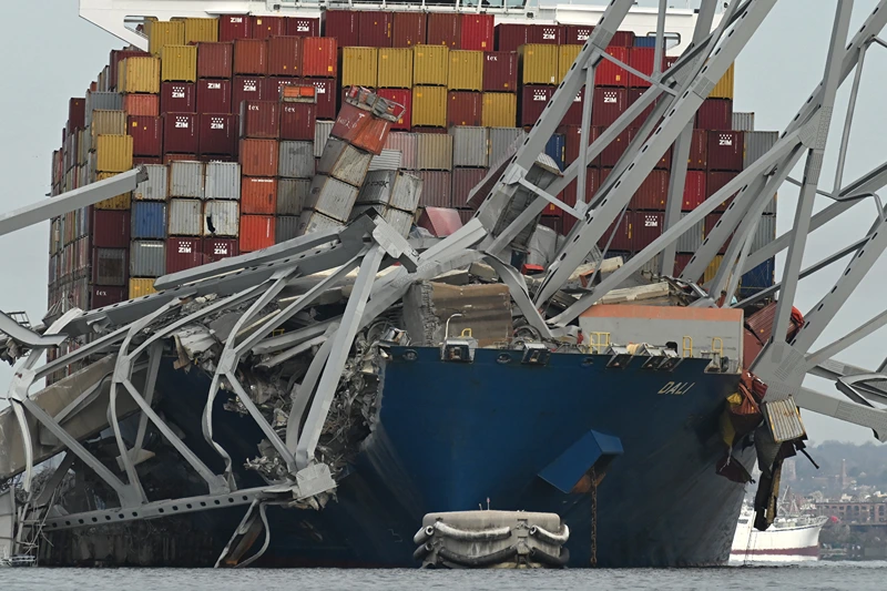 TOPSHOT-US-TRANSPORT-INCIDENT
TOPSHOT - The steel frame of the Francis Scott Key Bridge sits on top of the container ship Dali after the bridge collapsed, Baltimore, Maryland, on March 26, 2024. The bridge collapsed early March 26 after being struck by the Singapore-flagged Dali, sending multiple vehicles and people plunging into the frigid harbor below. There was no immediate confirmation of the cause of the disaster, but Baltimore's Police Commissioner Richard Worley said there was "no indication" of terrorism. (Photo by ROBERTO SCHMIDT / AFP) (Photo by ROBERTO SCHMIDT/AFP via Getty Images)