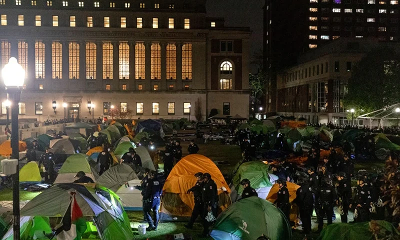 TOPSHOT - NYPD officers in riot gear enter Columbia University's encampment as they evict a building that had been barricaded by pro-Palestinian student protesters in New York City on April 30, 2024. Dozens of helmeted police flooded Columbia University's campus in the heart of New York City on April 30, 2024 to evict a building occupied by pro-Palestinian student protesters and detain demonstrators. Police climbed into Hamilton Hall via a second floor window they reached from a laddered truck, before leading handcuffed students out of the building into police vans. (Photo by Emily Byrski / AFP) (Photo by EMILY BYRSKI/AFP via Getty Images)