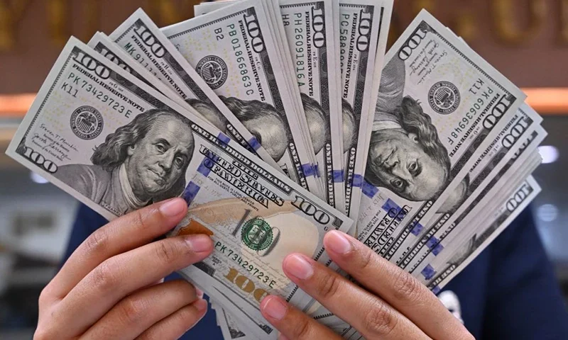 A clerk poses with US dollar banknotes at a money changer in Jakarta on May 2, 2024. (Photo by ADEK BERRY / AFP) (Photo by ADEK BERRY/AFP via Getty Images)