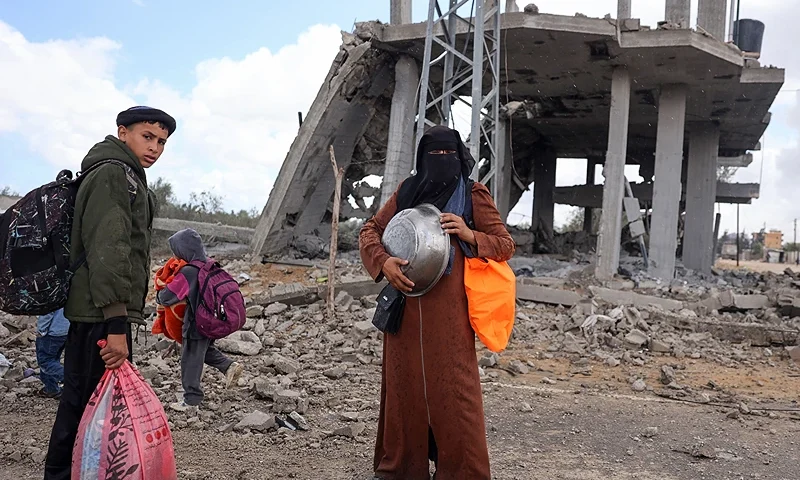 Displaced Palestinians in Rafah in the southern Gaza Strip carry their belongings as they await transportation following an evacuation order by the Israeli army on May 6, 2024, amid the ongoing conflict between Israel and the Palestinian Hamas movement. (Photo by AFP) (Photo by -/AFP via Getty Images)