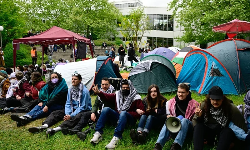 Pro-Palestinian activists sit in front of tents set up at the university campus of the Free University of Berlin, Germany, on May 7, 2024 as they demonstrate against Israel's war in the Gaza Strip which was sparked by Hamas's unprecedented October 7 attack. According to local media reports, activists set up a protest camp with tents in a courtyard of the university. The university has ordered the evacuation and called the police, who have cordoned off the area. (Photo by Tobias SCHWARZ / AFP) (Photo by TOBIAS SCHWARZ/AFP via Getty Images)