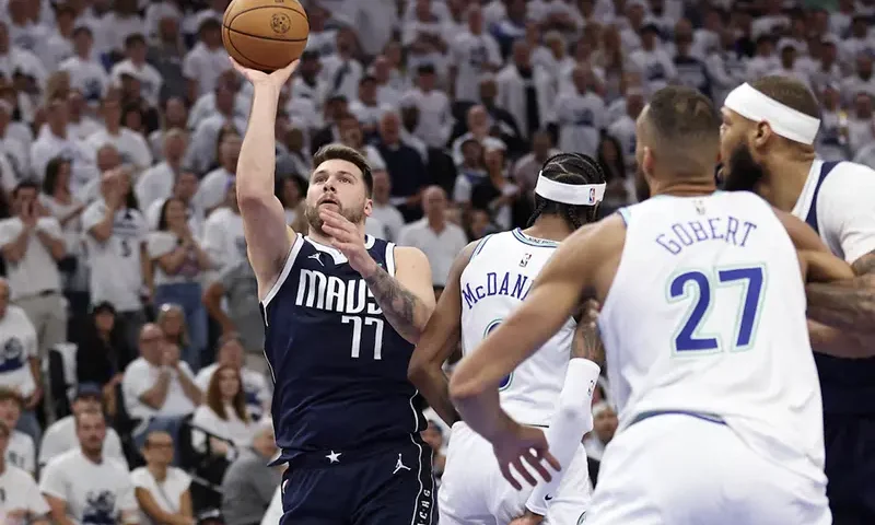 Dallas Mavericks guard Luka Doncic (77) shoots against Minnesota Timberwolves forward Jaden McDaniels (3) in the first quarter during game one of the western conference finals for the 2024 NBA playoffs at Target Center. Mandatory Credit: Jesse Johnson-USA TODAY Sports