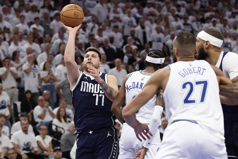 Dallas Mavericks guard Luka Doncic (77) shoots against Minnesota Timberwolves forward Jaden McDaniels (3) in the first quarter during game one of the western conference finals for the 2024 NBA playoffs at Target Center. Mandatory Credit: Jesse Johnson-USA TODAY Sports