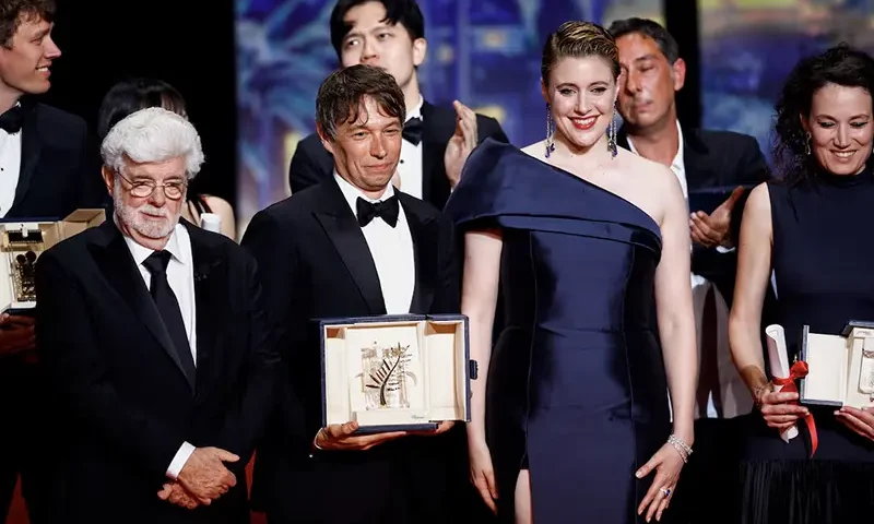 Director Sean Baker, Palme d'Or award winner for the film "Anora", poses for a family photo next to George Lucas, Greta Gerwig, Jury President of the 77th Cannes Film Festival and other winners at the end of the closing ceremony of the 77th Cannes Film Festival in Cannes, France, May 25, 2024. REUTERS/Stephane Mahe