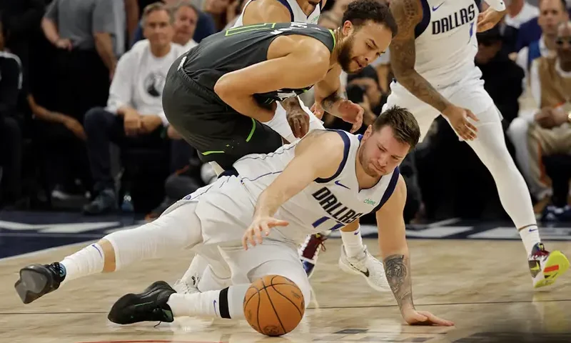 Dallas Mavericks guard Luka Doncic (77) and Minnesota Timberwolves forward Kyle Anderson (1) fight for a loose ball during the second quarter in game five of the western conference finals for the 2024 NBA playoffs at Target Center. Mandatory Credit: Bruce Kluckhohn-USA TODAY Sports