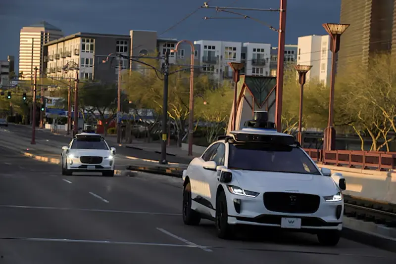 Two Waymo autonomous vehicles drive themselves down Central Avenue in Phoenix, Arizona, U.S., March 18, 2024. REUTERS/Caitlin O'Hara/File Photo