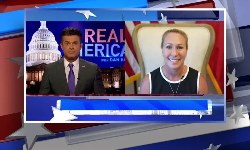 Video still from Real America on One America News Network showing a split screen of the host on the left side, and on the right side is the guest, Rep. Marjorie Taylor Greene.