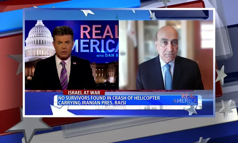Video still from Real America on One America News Network showing a split screen of the host on the left side, and on the right side is the guest, Dr. Walid Phares.