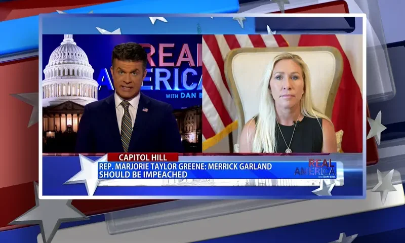 Video still from Real America on One America News Network showing a split screen of the host on the left side, and on the right side is the guest, Rep. Marjorie Taylor Greene.